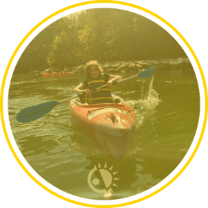 Child padeling a canoe in a lake.